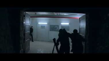 3 actors in a bunker. They are exiting 2 large doors into an elevator shaft.