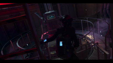 Actor walks across the walkway to the console platform. There are 2 control consoles along the guard rail. There are lighting and smoke coming from beneath. 