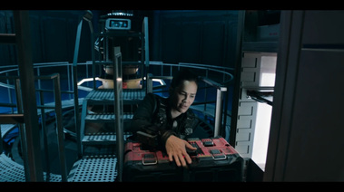 Engineer opens built-in storage space in the wall of the reactor room. The console platform is behind them with the metal walkway going around the circular room.