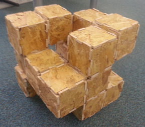 Particle board model of speaker concept. Form is made from a 3 x 3 'cube' with many missing blocks. The edges of each 'bloc' fit together like a jigsaw.