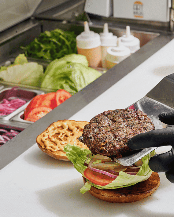 Stop Motion animation. Chef placing burger patty on bun with spatula and placing top of bun on patty to complete the sandwich. Image by Megan Morello San Diego Food and Lifestyle Photographer.