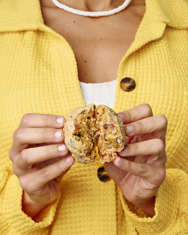 Woman wearing yellow shirt and pooka shell necklace. Her hands are splitting a cookie in half so the Turkish delight and graham cracker inside can be seen. Image shot by Megan Morello, San Diego and Southern California Food and Photographer.
