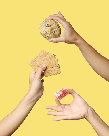 Three hands in frame holding Turkish delight and graham cracker cookie and relevant ingredients. Yellow  background. Image shot by Megan Morello, San Diego and Southern California Food and Photographer.