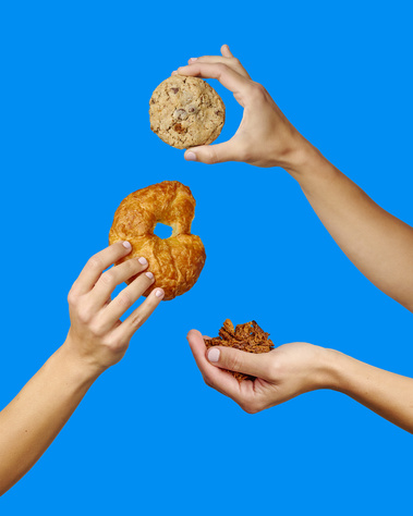 Three hands in frame holding Croissant crunch cookie and relevant ingredients. Royal Blue  background. Image shot by Megan Morello, San Diego and Southern California Food and Photographer.