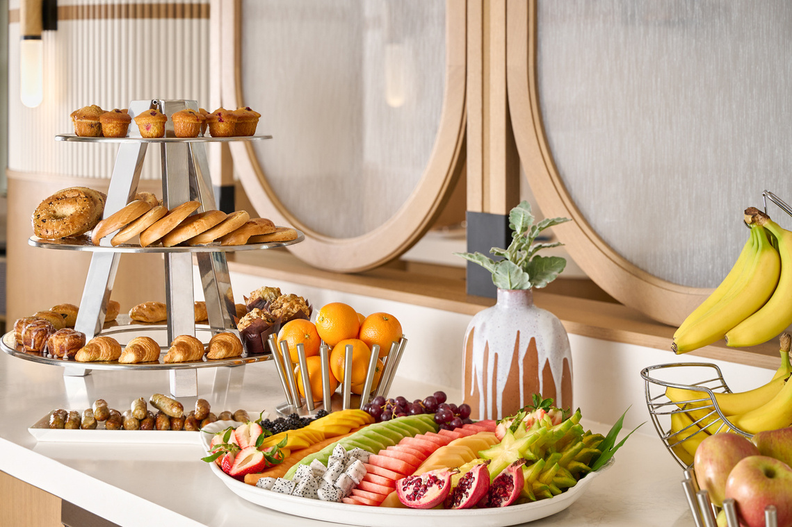 Interior Shot of upscale breakfast bar. Bagel Tower and bright Fruit Platter. Set in a room of creams or natural woods. Image by Megan Morello Commercial food photographer and lifestyle photographer in San Diego, Southern California.