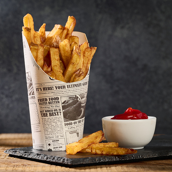 French fries in an upright paper container. Small bowl of ketchup on right side of fries.Image by Megan Morello San Diego Food and Lifestyle Photographer.