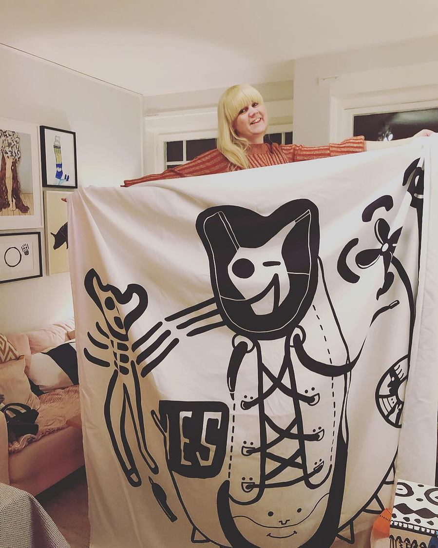 Woman holding an illustrated duvet cover.