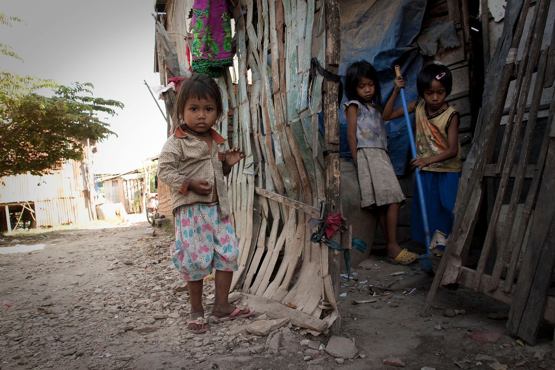 Article 18: "...children of working parents have the right to benefit from child-care services and facilities for which they are eligible." Children at home on Stung Meanchey dump site while their parents collect rubbish, Cambodia