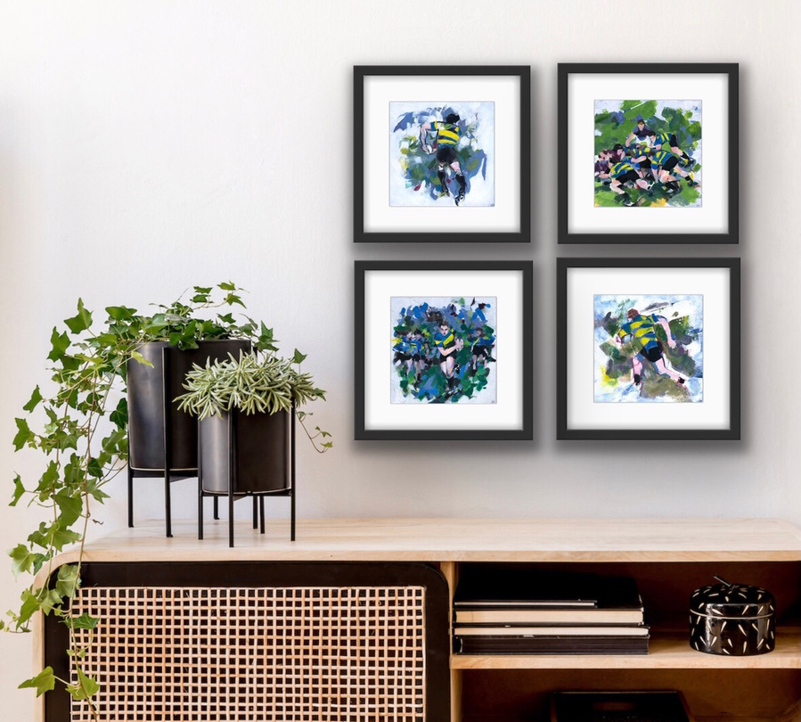 A set of four rugby artworks hanging framed on a wall in a square, showing the colourful, dynamic artworks hanging together.