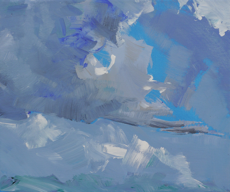 Heavy clouds gather in a bright blue sky.