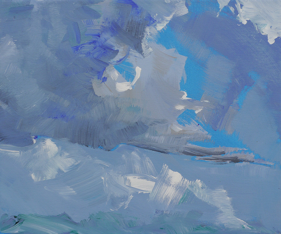 Heavy clouds gather in a bright blue sky.