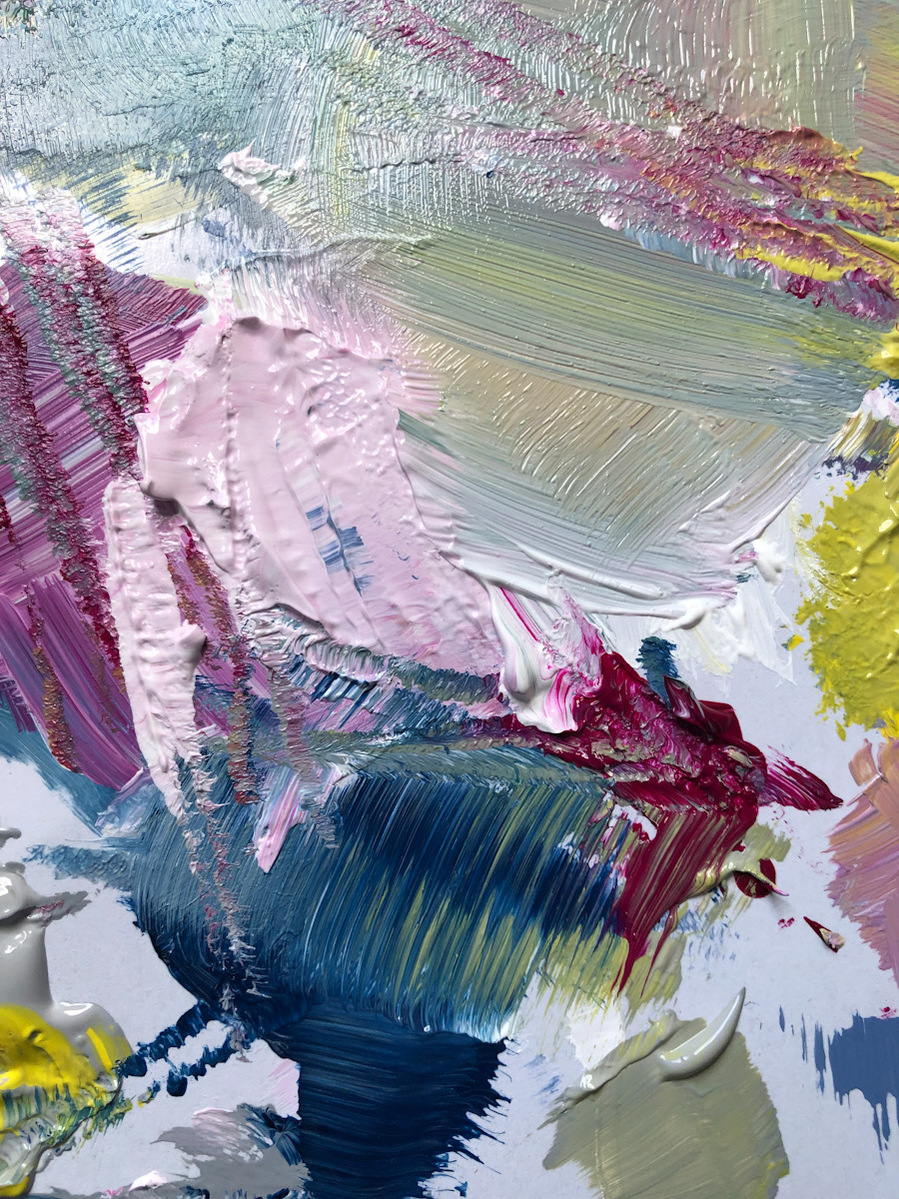 A paint palette close up with rose pink smudged into prussian blue, scratched burgundy and side swathes of dirty lemon yellow.