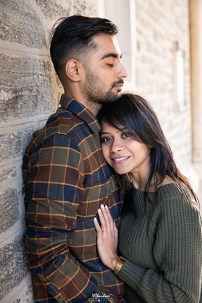 couple poses with guy against the wall and girl leans into his chest