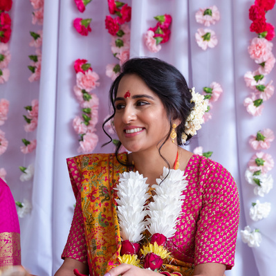 bride smiling during haldi ceremony with flower background