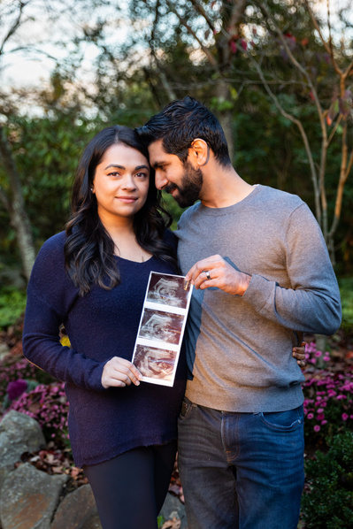 Couple holding a sonogram for baby announcement
