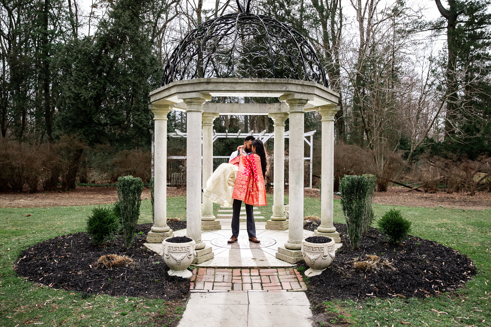 Couple engagment session under a gazebo in a garden
