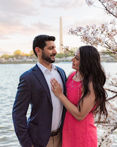 Couple engagement session in front of Washington monument with cherry trees