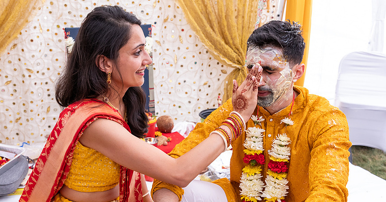Sister applying haldi on brother during haldi ceremony