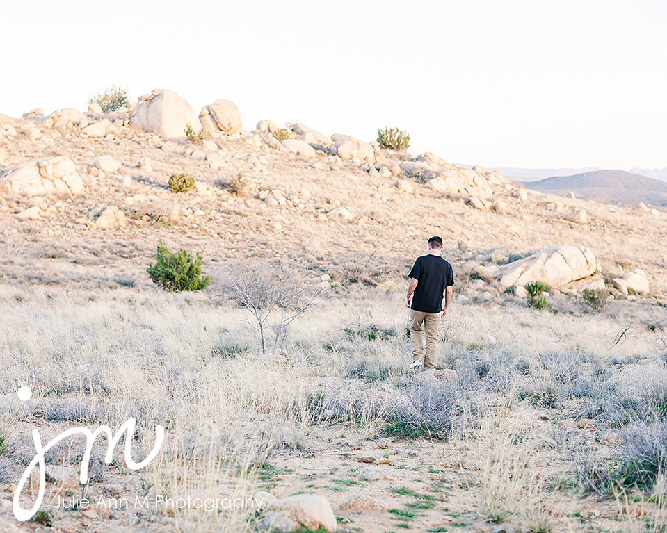 Young Man walking in desert hills for High School Senior Photography Session.