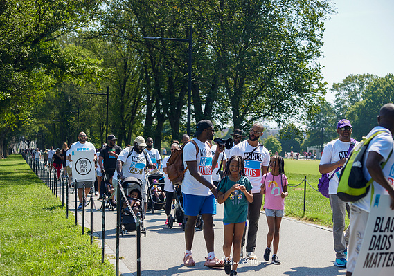 Edward Smith, III, (left) talks with Matthew Gions (right) who brought his two daughters (pictured front) and son (not pictured) to the march.  Smith leads the march from the MLK, Jr. memorial to the National Mall.  