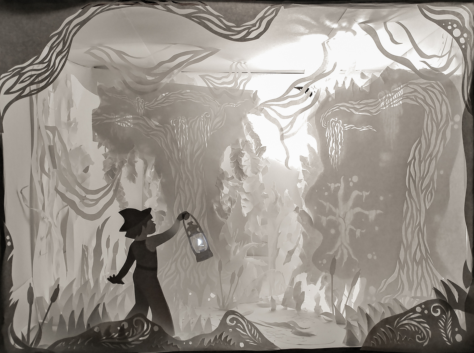 paper sculpture in light box of little adventurous girl exploring a magic swamp