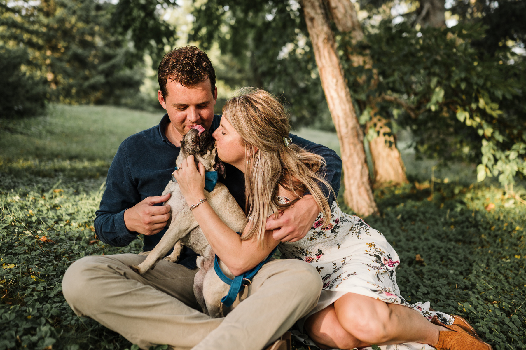 a couple cuddles with the pet pug during their boston engagement session 
