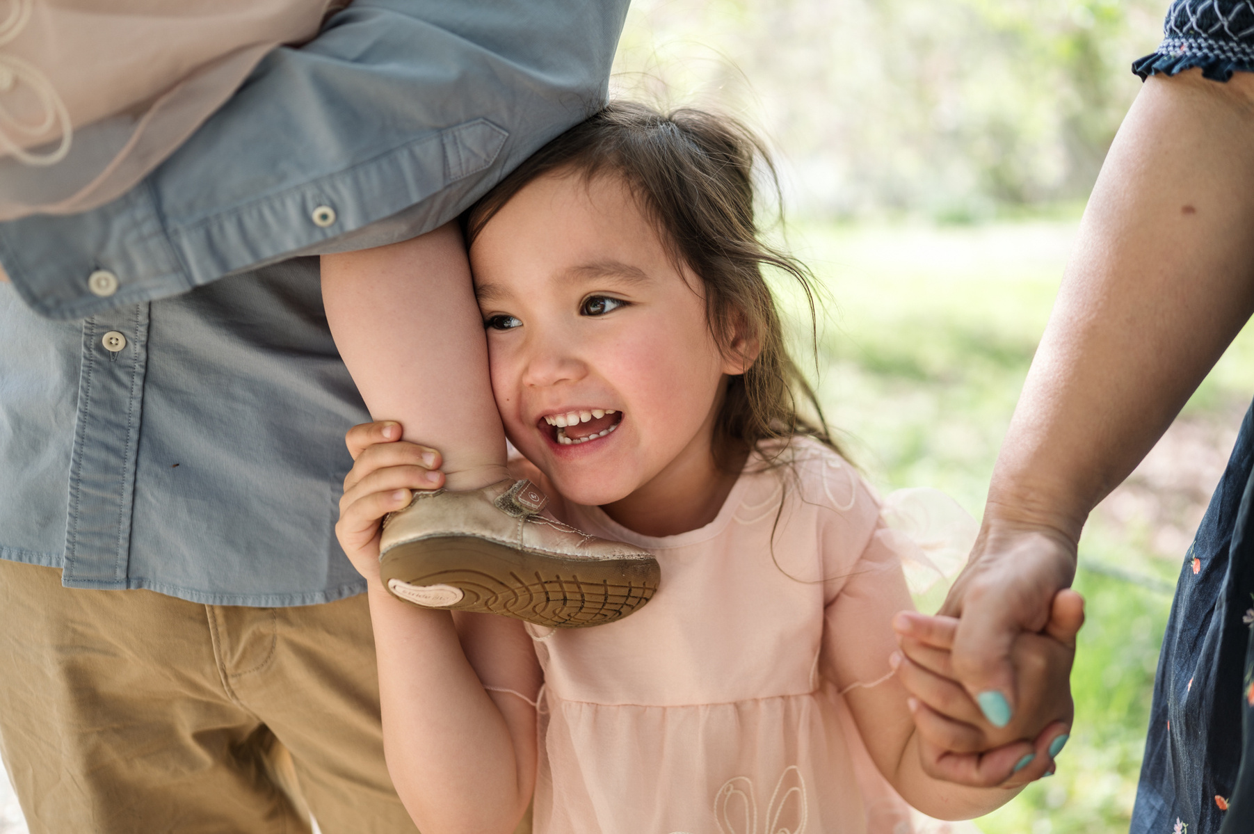 A young girl smiles during her spring family photo session in the Arnold Arboretum