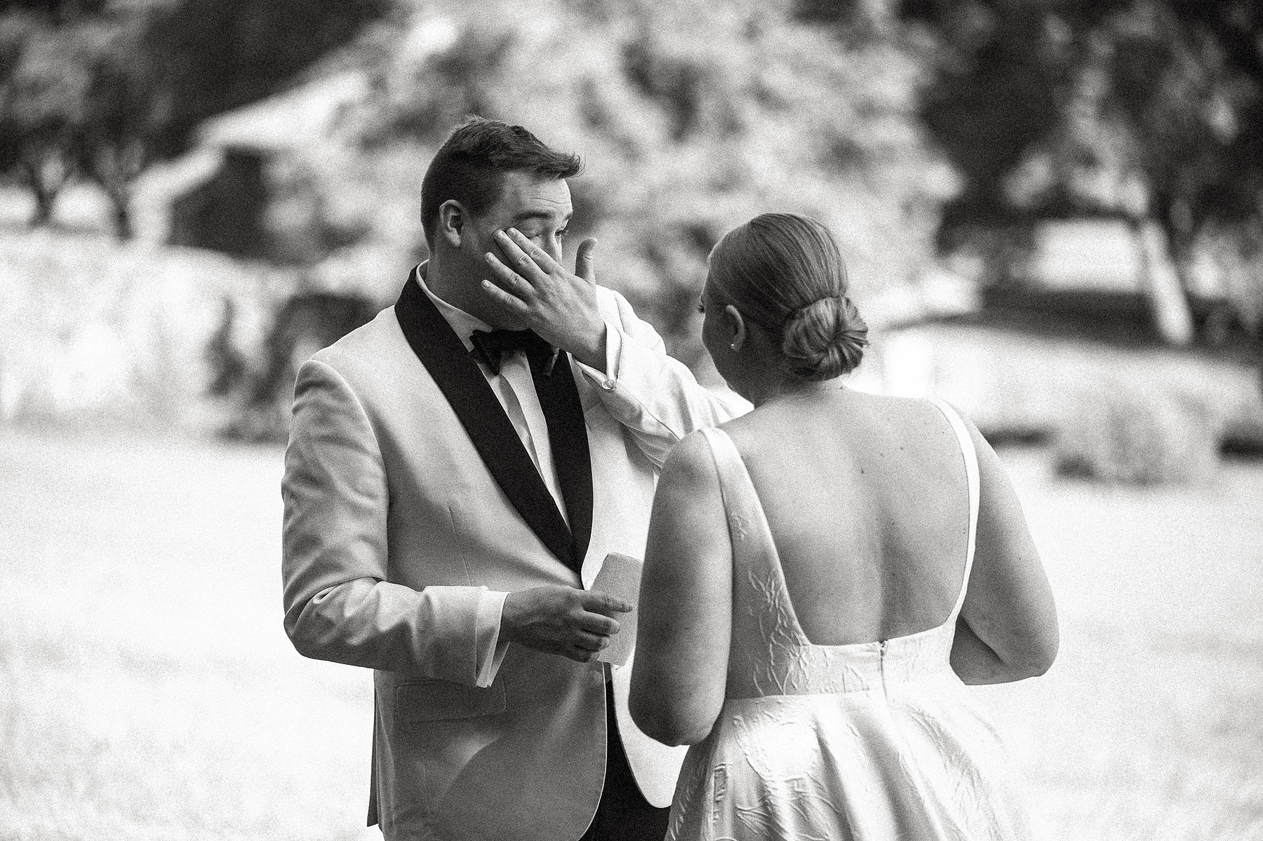 A groom wipes away tears as he shares private vows with his wife at their Crane Estate wedding