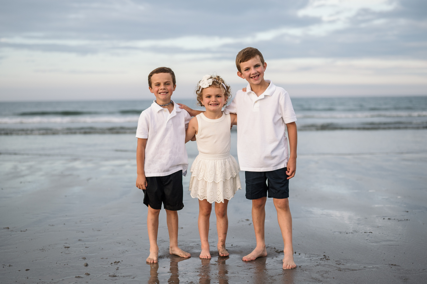 Three children pose by the ocean at an extended family photo session with Grandparents at Nantasket Beach in Hull MA by Boston family photographer Korri Leigh Crowley