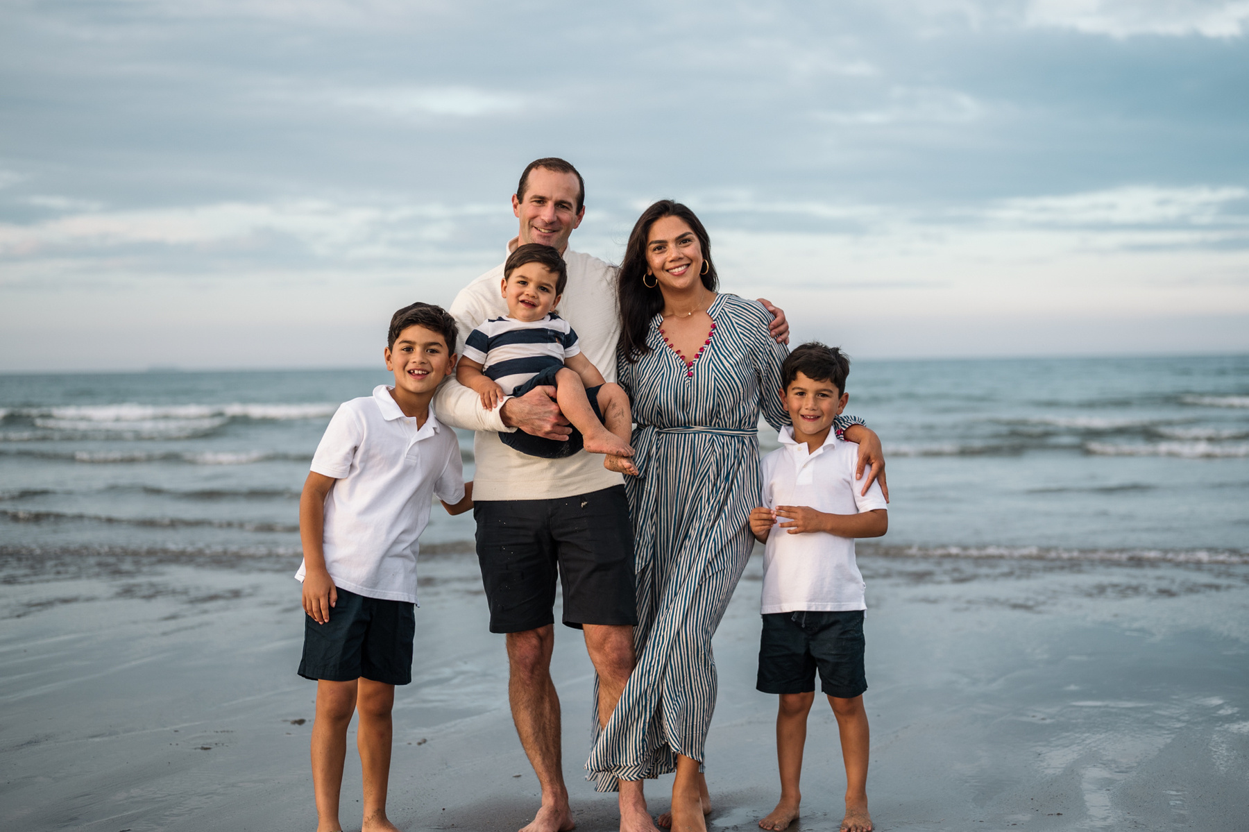 A family poses during their summer family photo session on Nantasket Beach in Hull MA