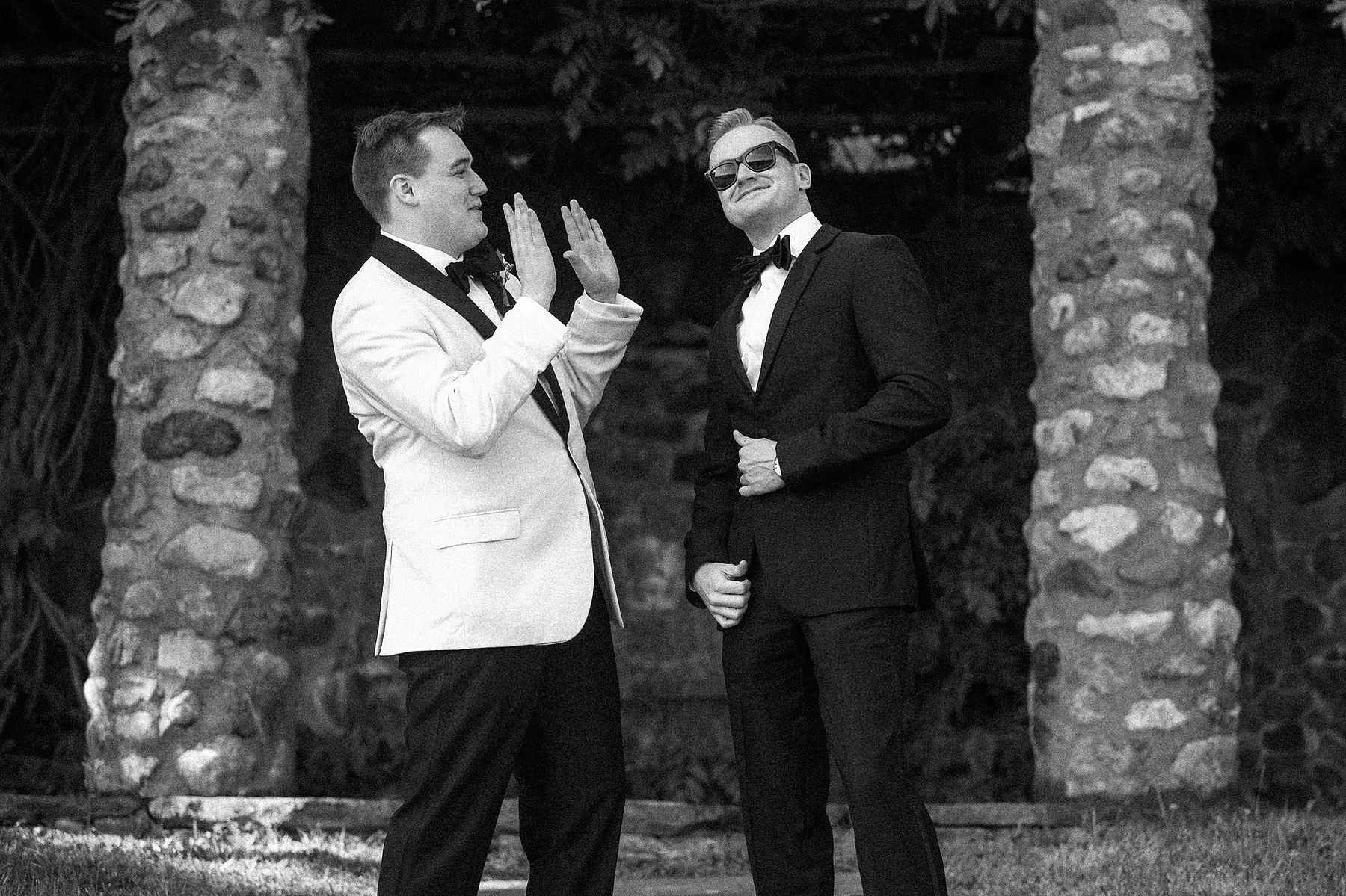 A groom laughs at his brother wearing sunglass at a Barn at Castle Hill wedding