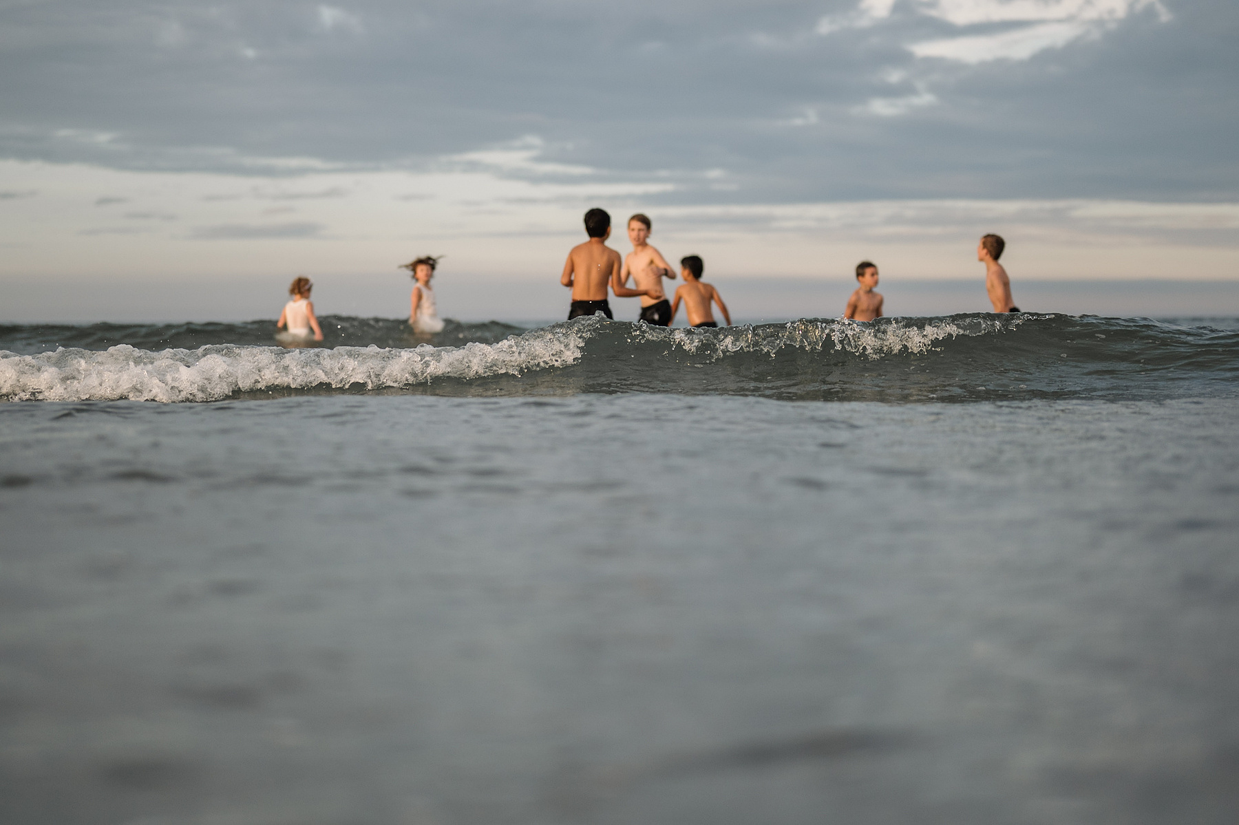 Children in the ocean during their summer vacation photography session at Nantasket Beach by Boston family photographer Korri Leigh Crowley