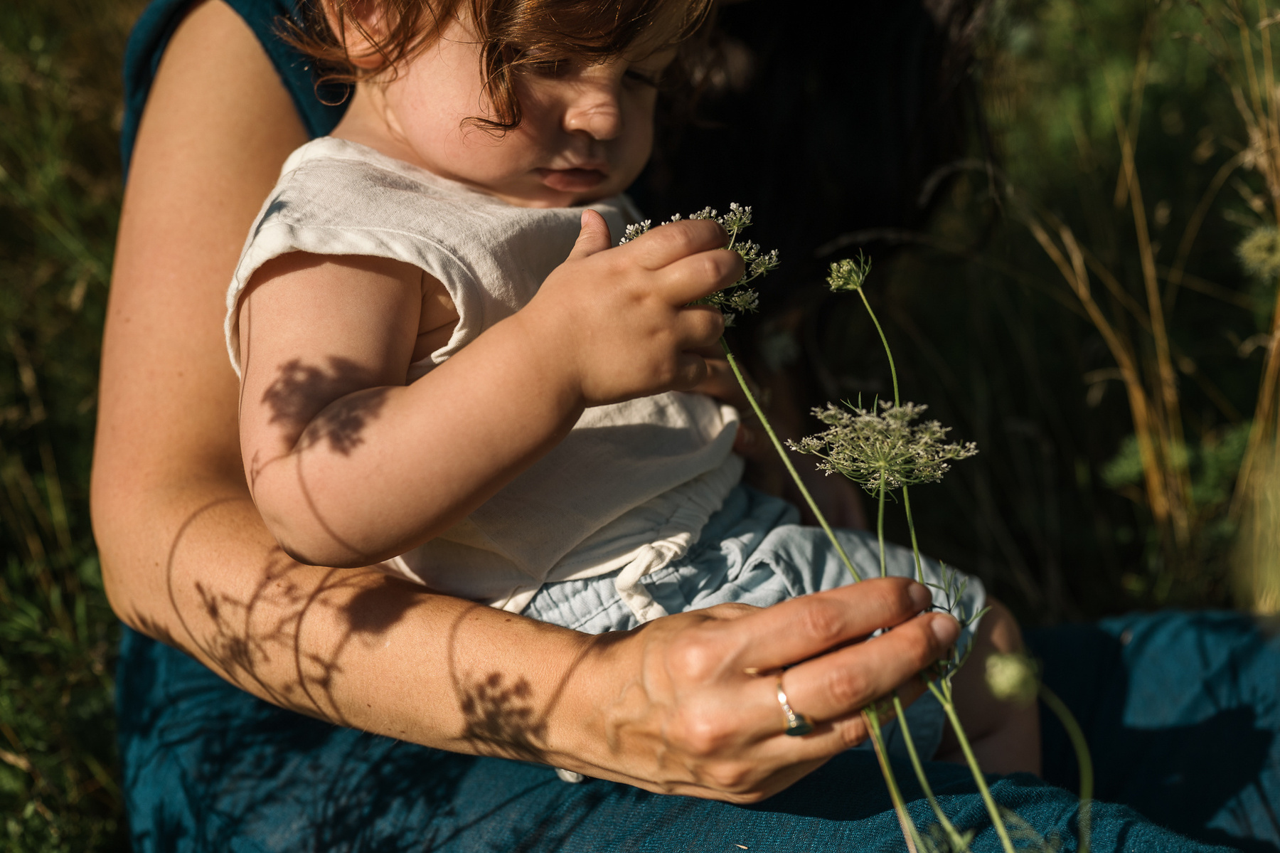 A mother and baby son in the flowers during their Brookline Family Photography session at Fisher Hill Reservoir Park in Brookline MA