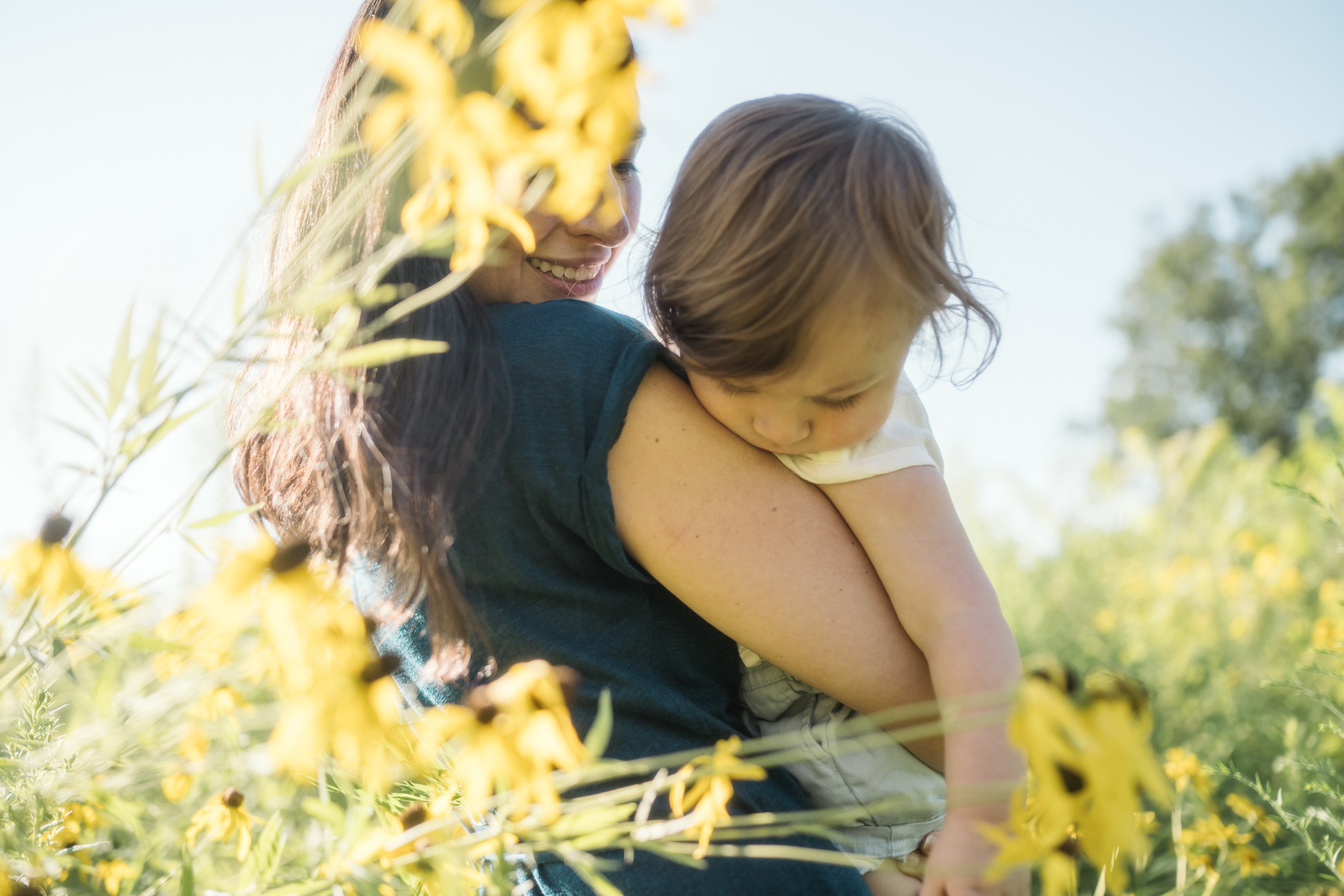 A mother looks at her baby son in the sunshine at Fisher Hill Reservoir Park in Brookline MA