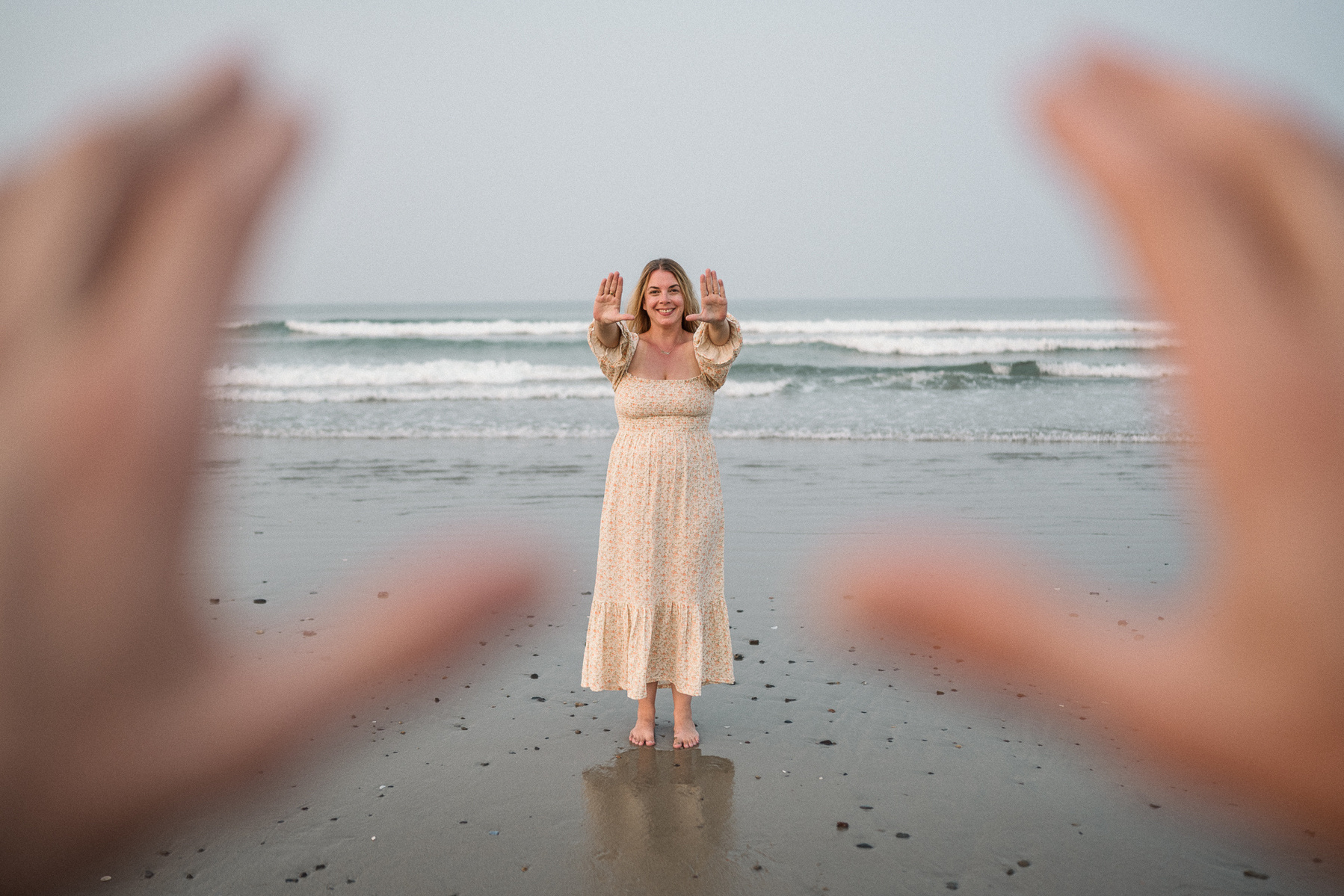 A couple extended their hands towards each other at their nantasket beach engagement session by Korri Leigh Photography