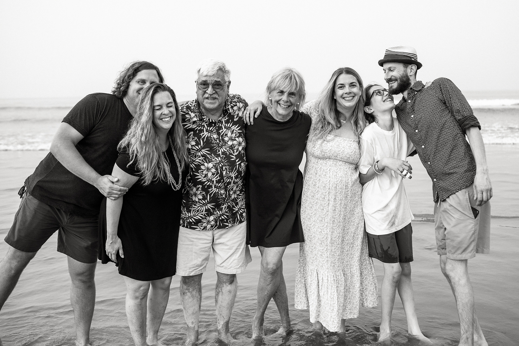 A family poses and smiles together on Nantasket Beach at their Hull family photography session by Korri Leigh Photography