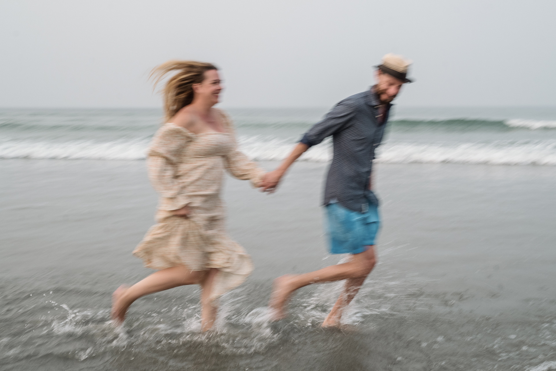 A couple runs through the atlantic ocean at their nantasket beach engagement session by Korri Leigh Photography