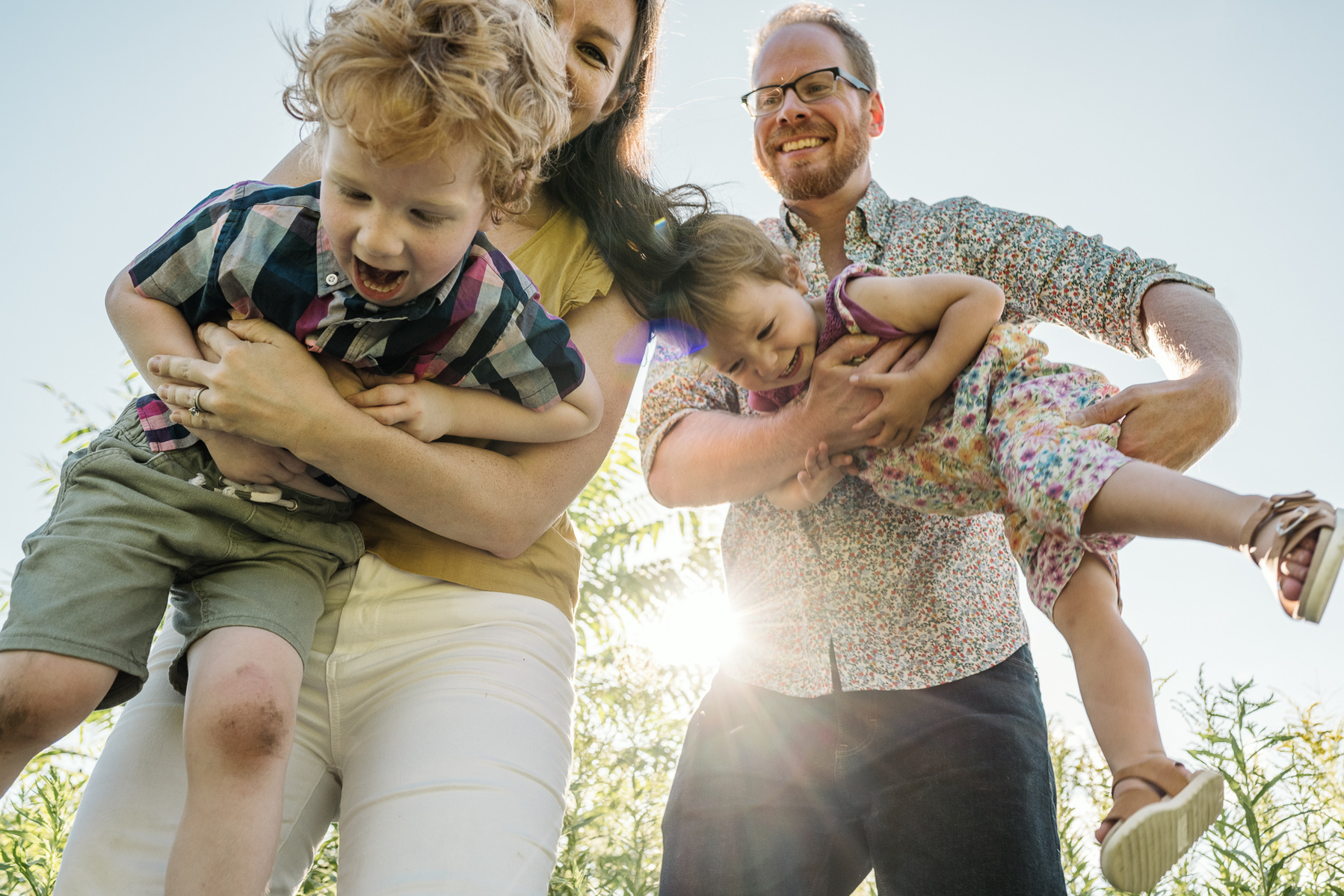 Parents playfully pose with their kids during a family photo session at Fisher Hill Reservoir Park in Chestnut Hill by Brookline family photographer Korri Leigh Photography