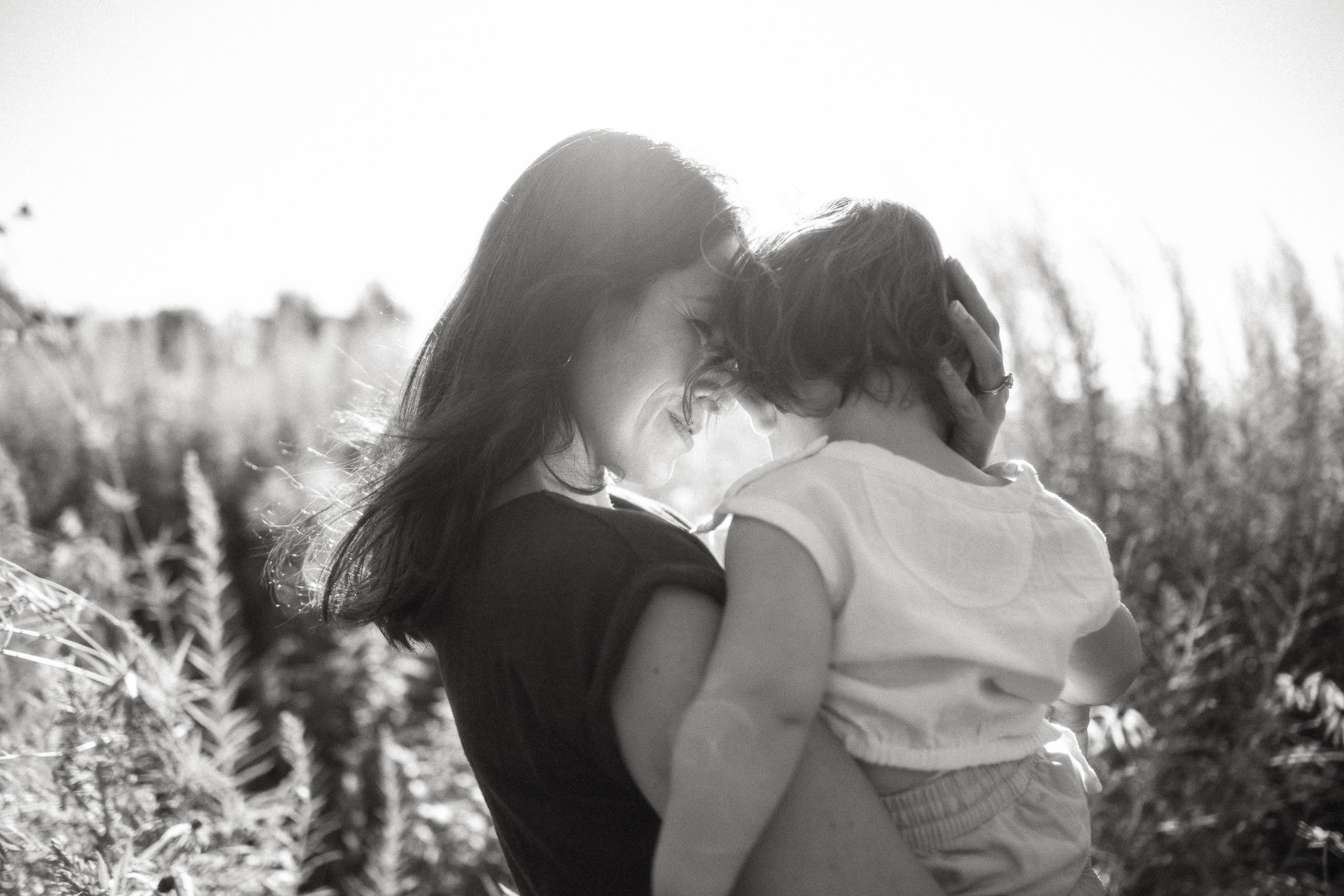 A mother looks at her baby son in the sunshine at Fisher Hill Reservoir Park in Brookline MA