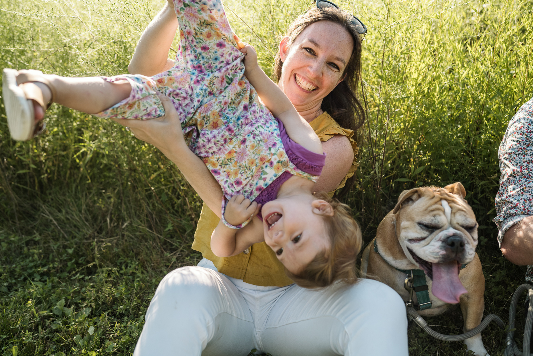 Parents play with their young children at a family photo session at Fisher Hill Reservoir Park in Chestnut Hill by Brookline family photographer Korri Leigh Photography