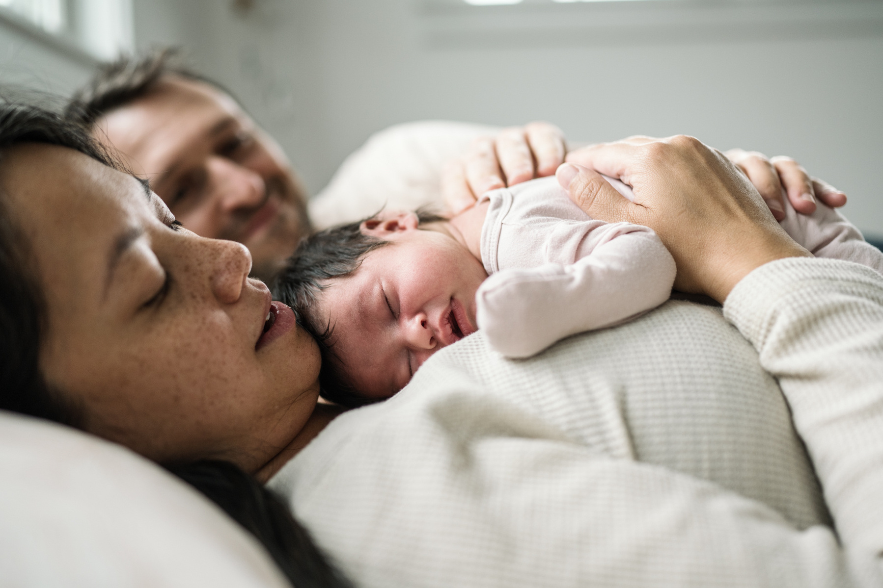 Mom and Dad's hands on a newborn  during a Boston newborn photography session
