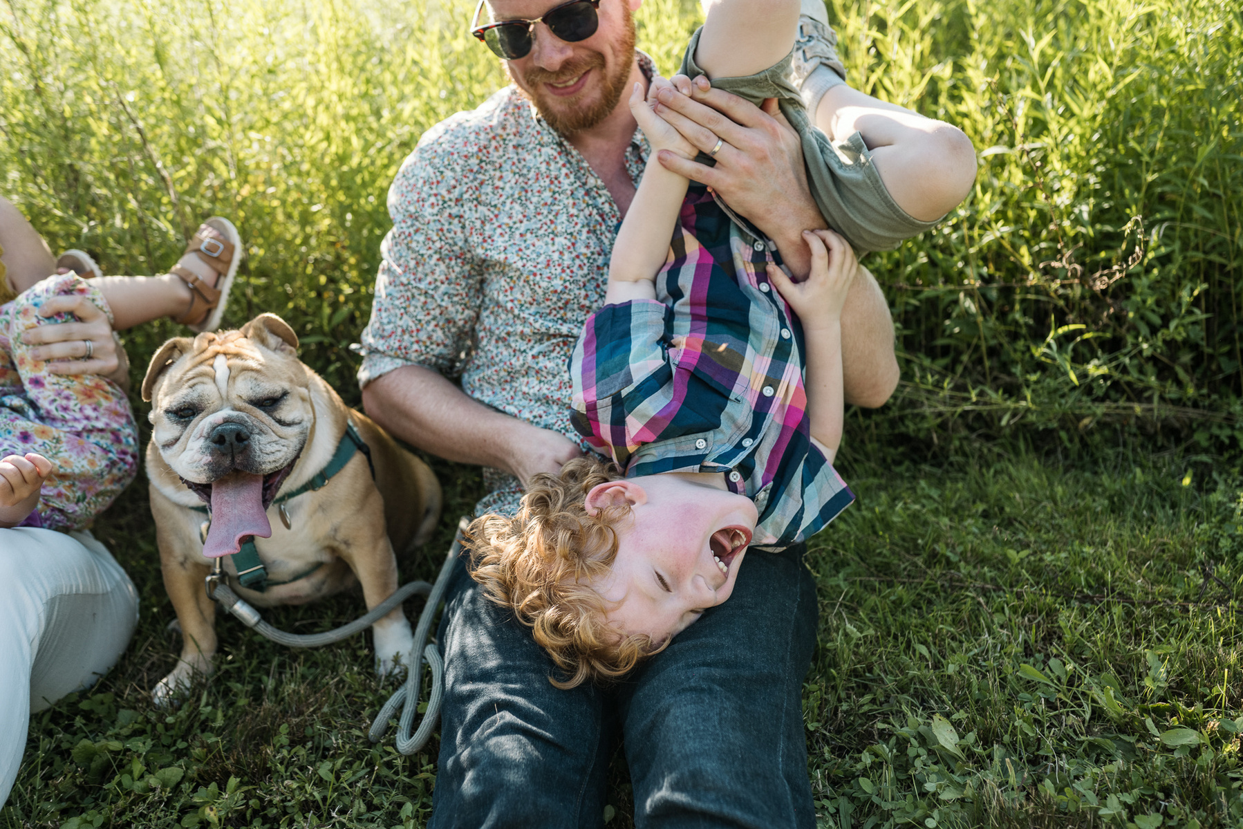 Parents play with their young children at a family photo session at Fisher Hill Reservoir Park in Chestnut Hill by Brookline family photographer Korri Leigh Photography