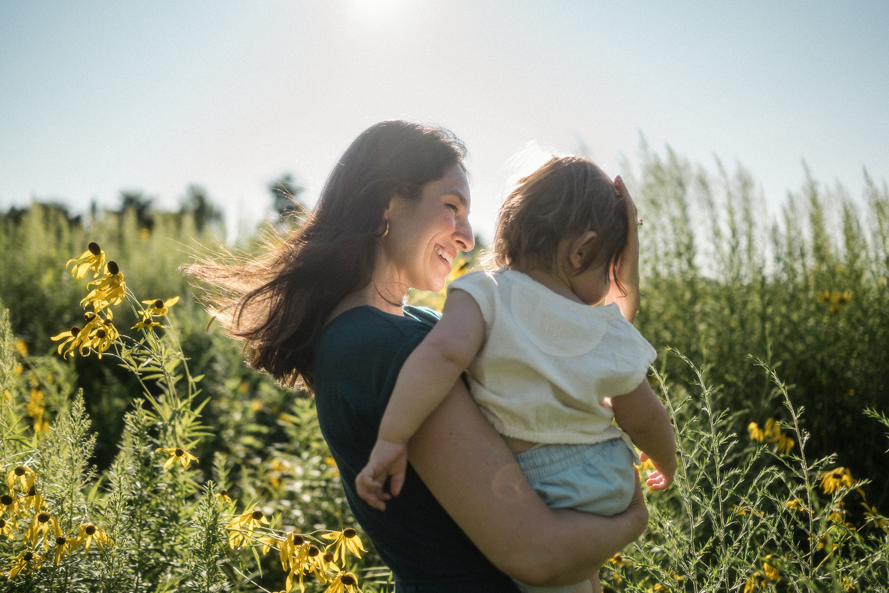 A mother smiles at her son during their Boston Family Photography session at Fisher Hill Reservoir Park in Brookline MA