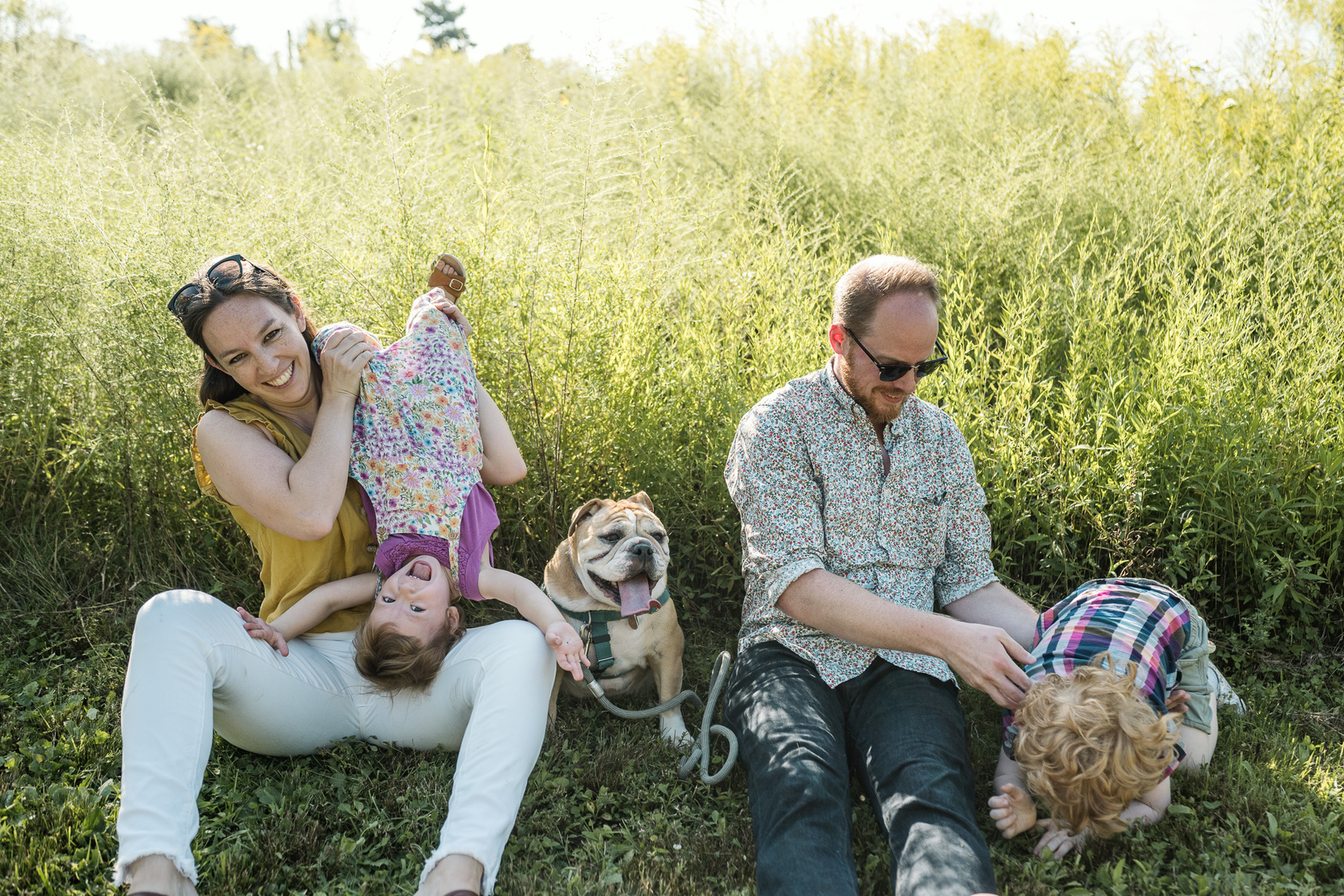 Parents play with their young children at a family photo session at Fisher Hill Reservoir Park in Chestnut Hill by Brookline family photographer Korri Leigh Photography