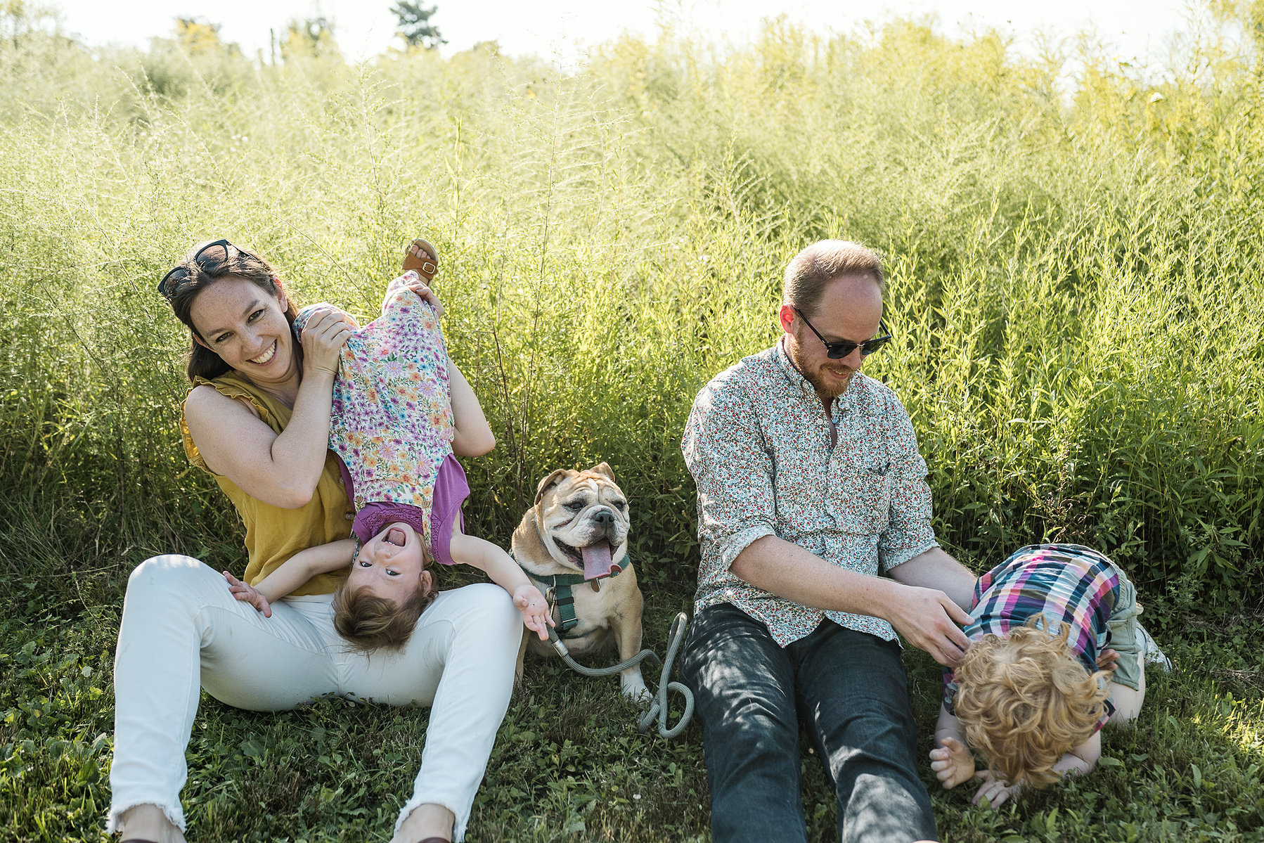 Parents play with their young children at a family photo session at Fisher Hill Reservoir Park in Chestnut Hill by Brookline family photographer Korri Leigh Photography