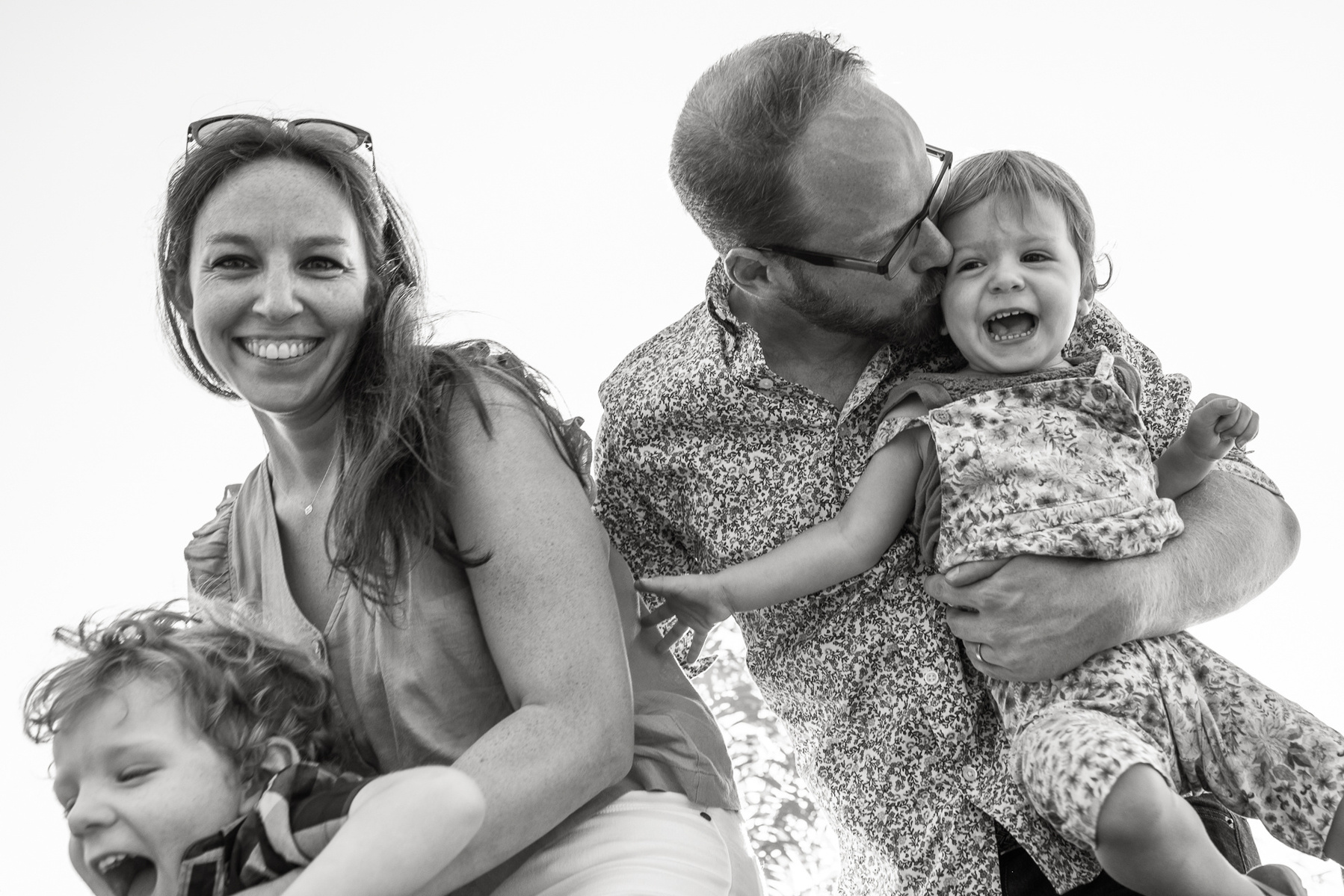 Parents playfully pose with their kids during a family photo session at Fisher Hill Reservoir Park in Chestnut Hill by Brookline family photographer Korri Leigh Photography