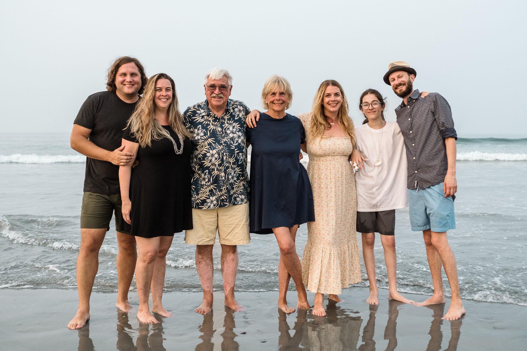 A family poses and smiles together on Nantasket Beach at their Hull family photography session by Korri Leigh Photography