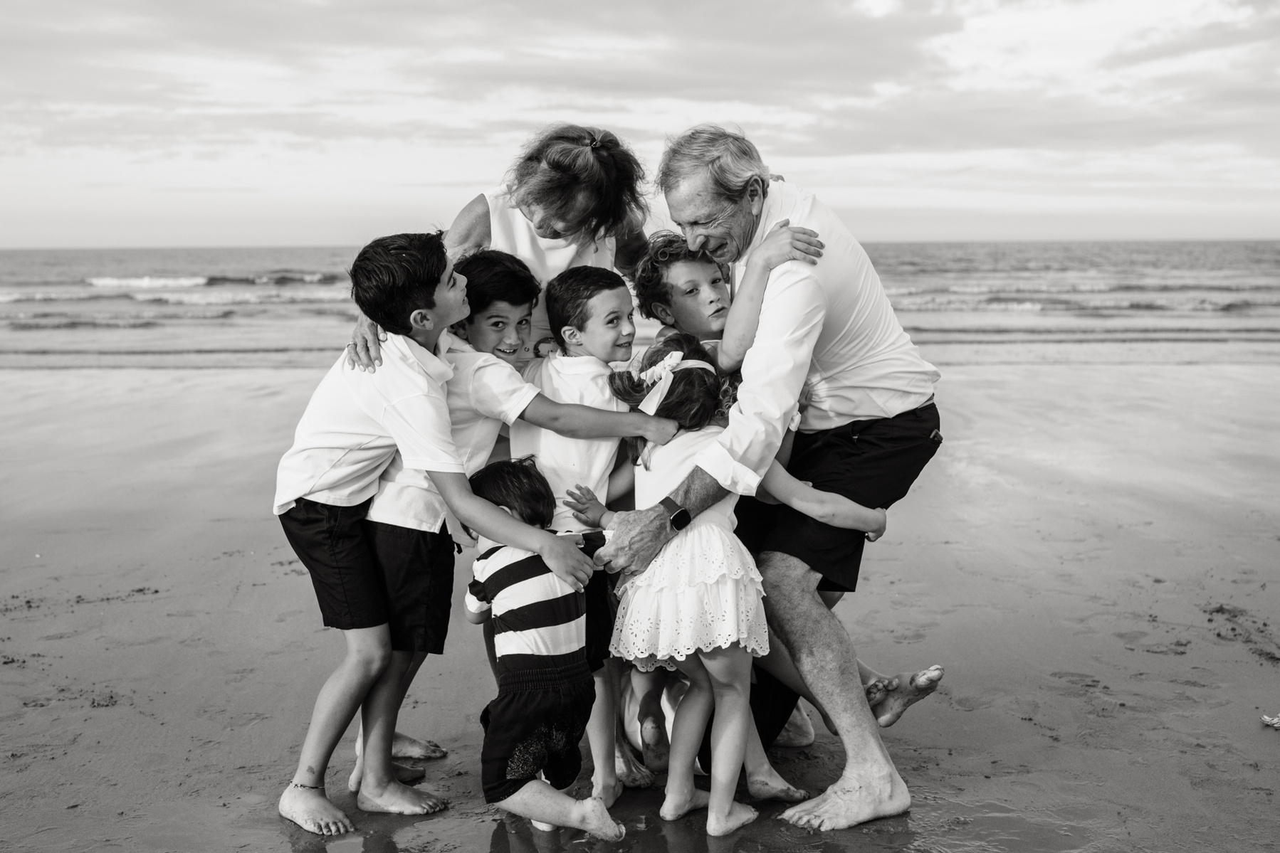 An extended family photo session with Grandparents hugging at Nantasket Beach in Hull MA by Boston family photographer Korri Leigh Crowley