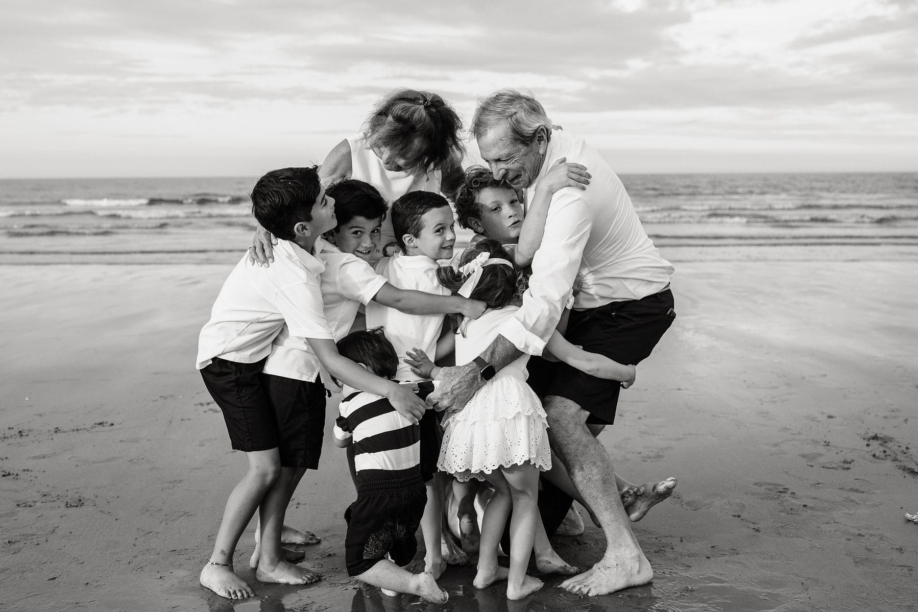 An extended family photo session with Grandparents hugging at Nantasket Beach in Hull MA by Boston family photographer Korri Leigh Crowley