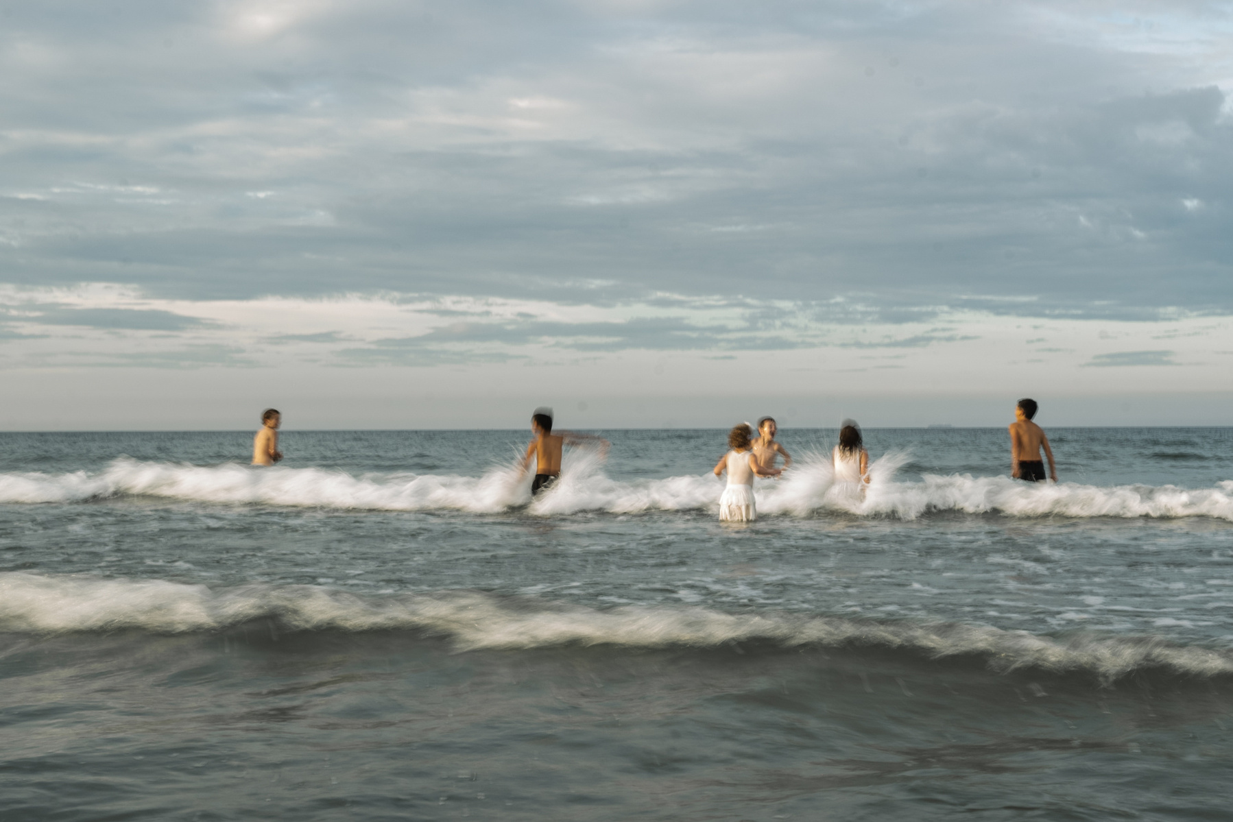 An artsy photo of kids playing in the water at Nantasket beach during their summer family photography session by West Roxbury family photographer Korri Leigh Crowley